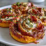 Easy appetizer of puff pastry spirals filled with marinara, mozzarella, and pepperoni—great for parties or snacks.  