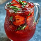 Refreshing Strawberry Basil Lemonade Pitcher, perfect for a sunny party cooler on display.