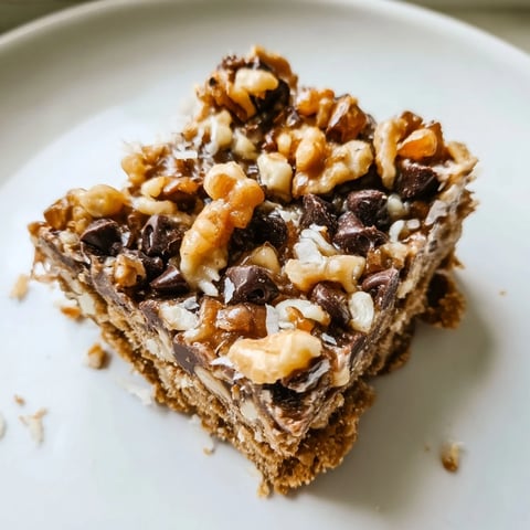 Warm, golden Hello Dolly Bars, offering a sweet symphony of chocolate, coconut, and gooey condensed milk.