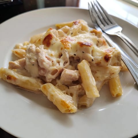 Fresh chives garnish this hearty, cheesy Chicken Ranch Pasta Bake casserole with golden edges.  