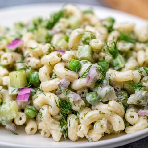 Chilled Creamy Dill Pickle Pasta Salad served in a white bowl for a spring potluck.