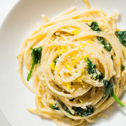 Vibrant green spinach and twirled thin spaghetti coated in a rich, pale yellow lemon cream sauce.  