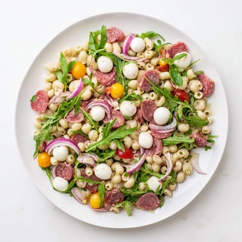 Vibrant Spring Antipasto Pasta Salad features ditalini with peppery arugula, salami, and mozzarella pearls.