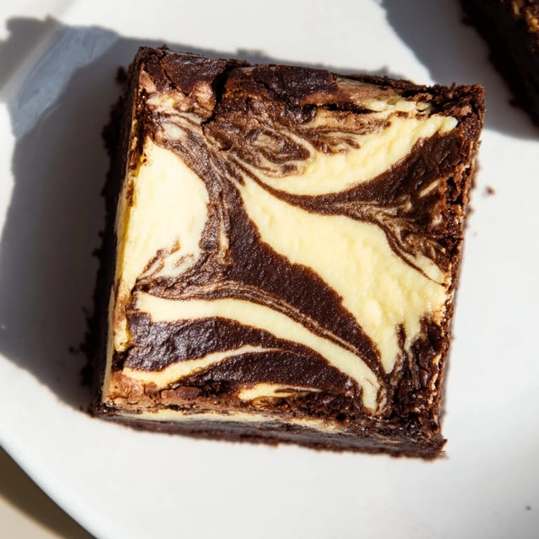 Perfectly baked cheesecake brownies, a dessert that blends tangy cheesecake with decadent brownie chocolate.