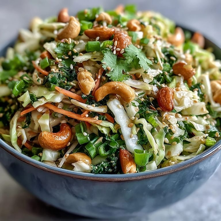 Vegan and gluten-free Asian Cabbage Salad featuring crisp vegetables, green onions, and a zesty lime-soy dressing, providing a healthy and crunchy lunch or dinner option.