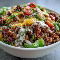 A deconstructed Easy Big Mac in a Bowl features seasoned ground beef, crisp romaine, cheddar, and homemade special sauce.
