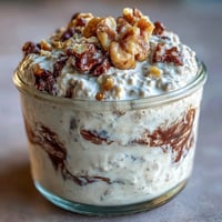 Creamy overnight oats with protein powder, chocolate chips, and almond butter, inspired by classic cookie dough for a nutritious breakfast.